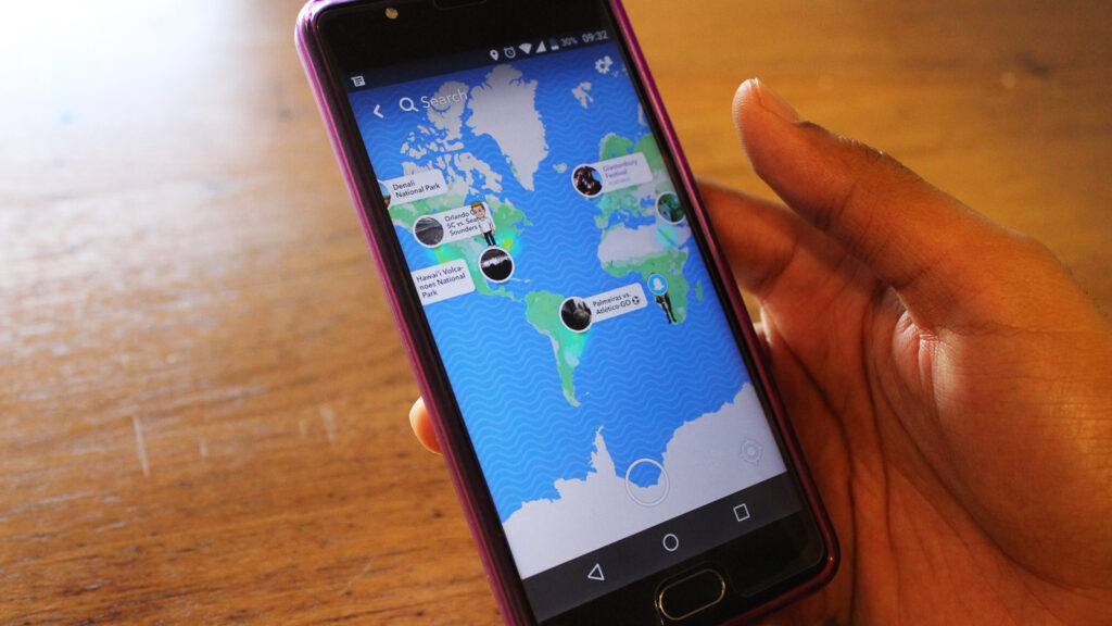 zoomed in view of person holding phone with world map on screen